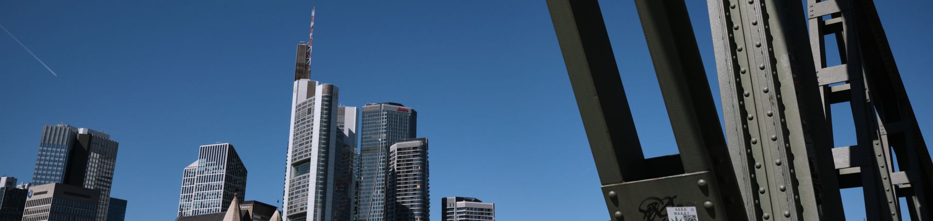 You can see the Frankfurt skyline against a blue sky. On the right-hand side, you can still see part of a steel bridge.